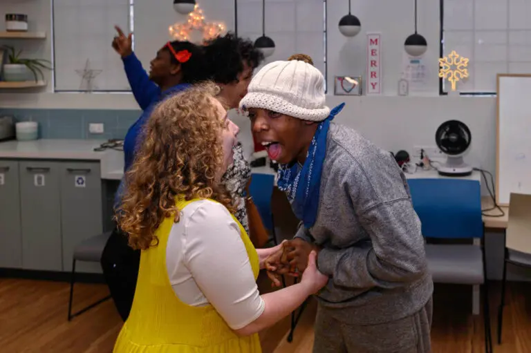 People smiling, dancing, and holding hands.