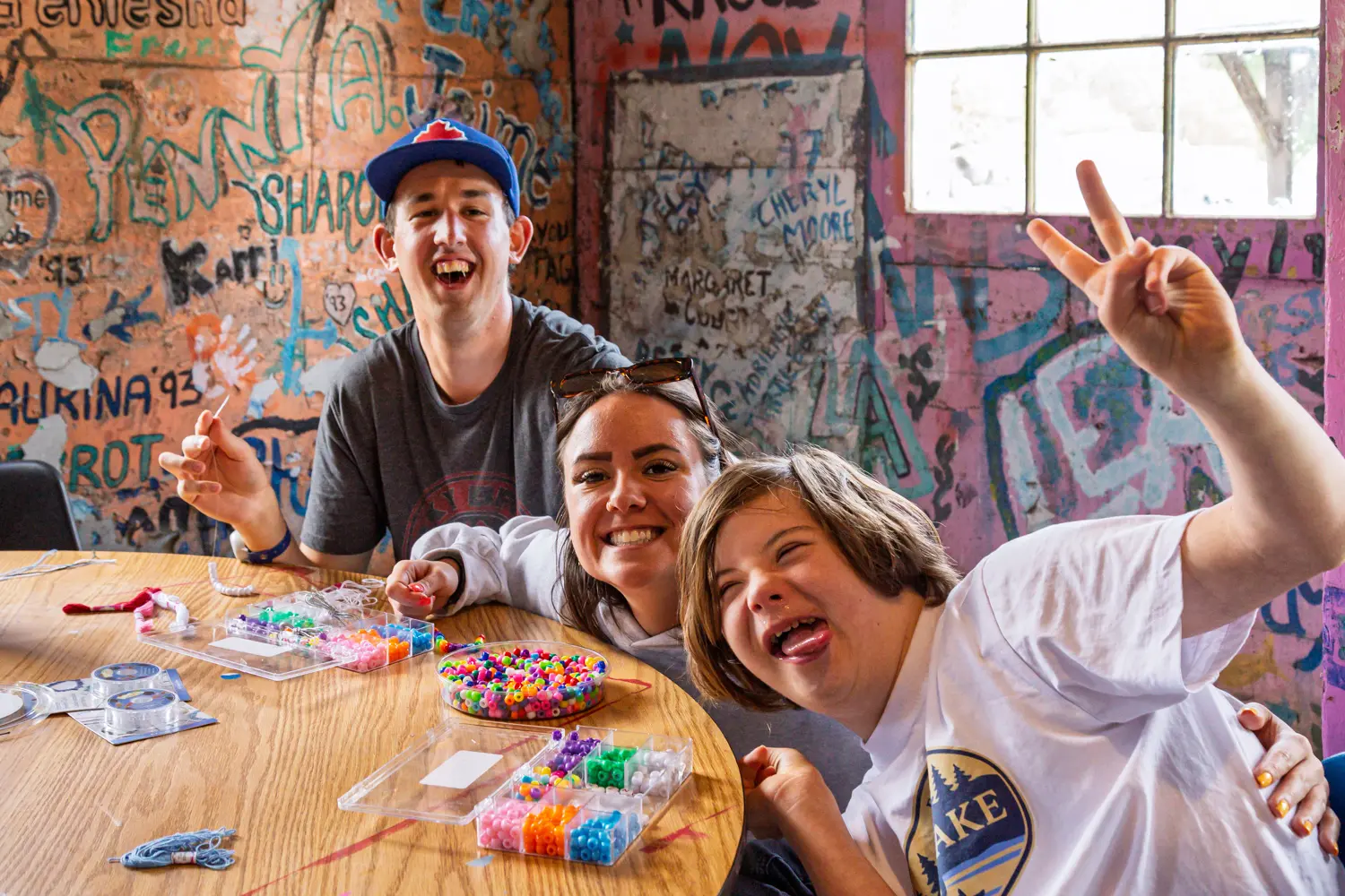 Participants take part in a beading activity at Shadow Lake Centre, using colourful craft materials while gathered around a table in a vibrant creative space.