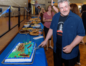 Bob with his classic grin poses while cutting his cake
