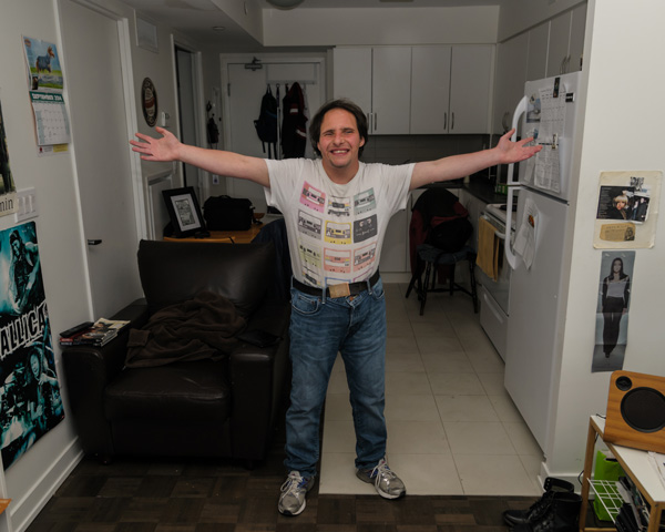 Man in his kitchen with arms out like a hug
