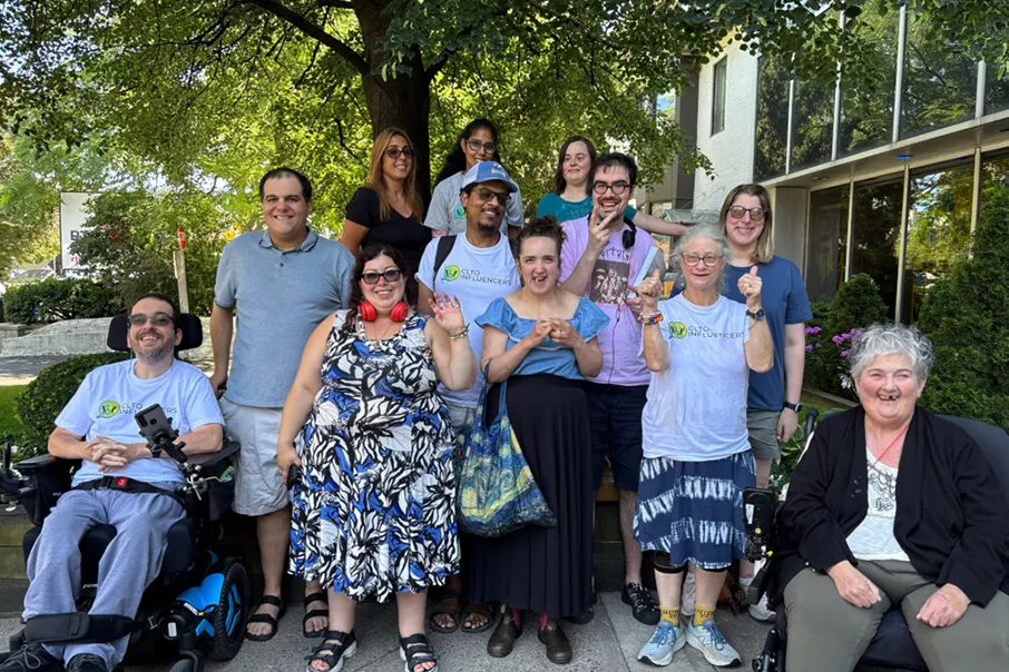Group of community members smiling and posing together outdoors, celebrating inclusion, connection, and belonging