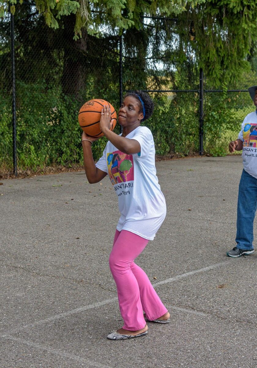 2 people in a basketball court, one person about to shoot for the hoop!