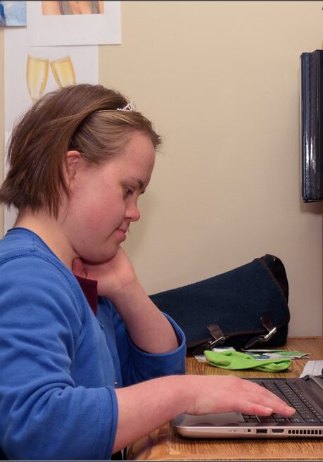 Girl at desk sitting in front of a laptop